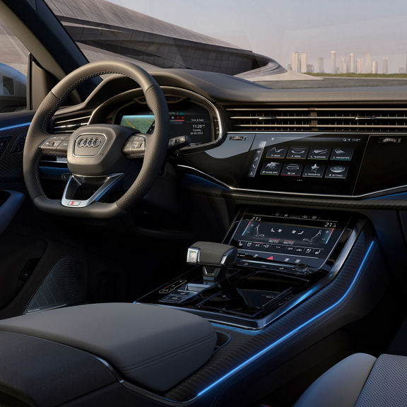 Internal view of drivers control area with city skyline seen through the front window.