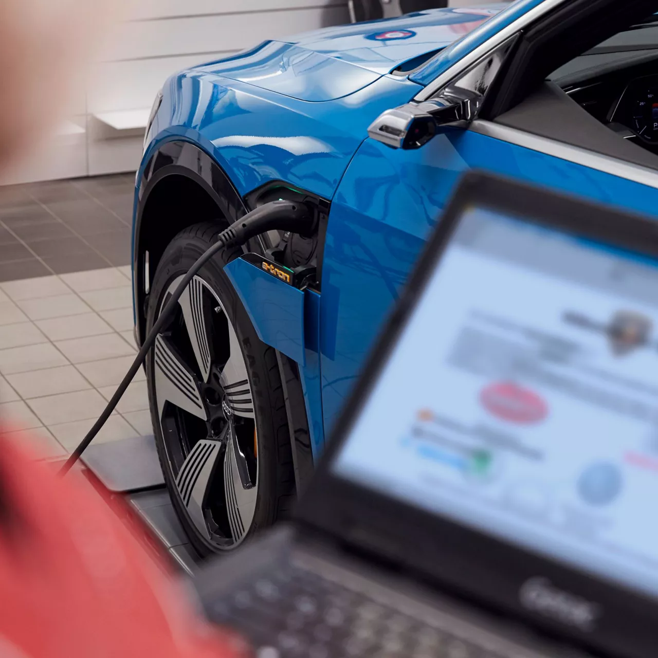 A blue Audi electric vehicle plugged in on charge at an Audi service centre