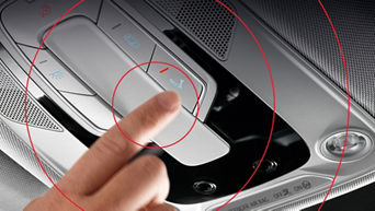 Hand hält einen Zeigefinger an die Service-Call-Taste eines Audi