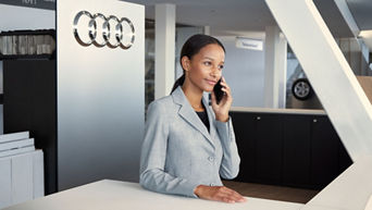 Eine Frau steht am Empfang von Audi und telefoniert